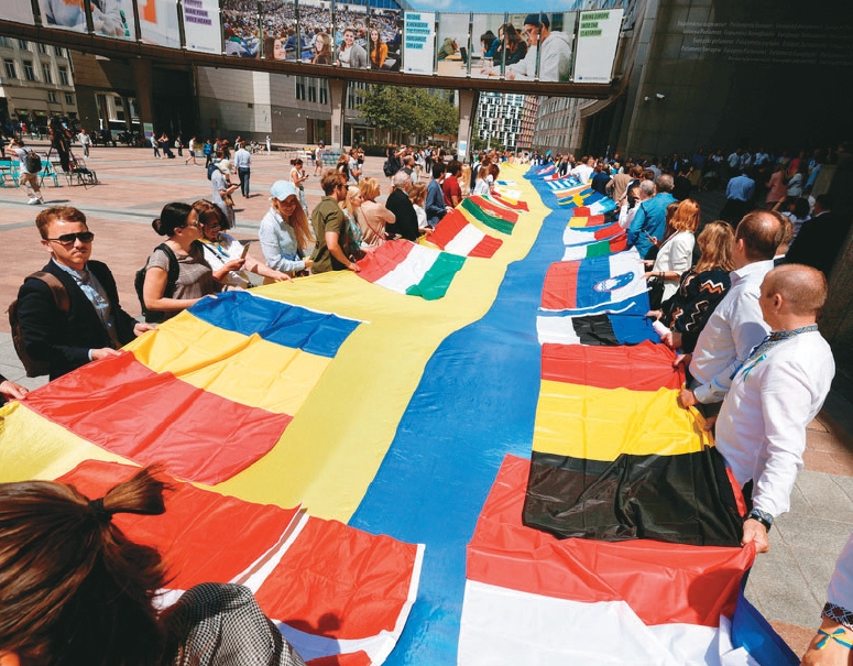 歐盟議員與烏克蘭代表在歐盟領袖開會前，於歐盟議會大樓外展示30公尺長的烏克蘭國旗，呼籲歐盟領袖讓烏克蘭加入歐盟。圖／路透