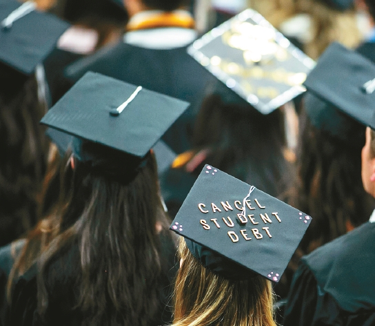 大學學費昂貴，學生未出社會就背負沉重學貸。圖為愛荷華大學畢業典禮上，學士帽上有著「取消學貸」的字樣。圖／美聯社