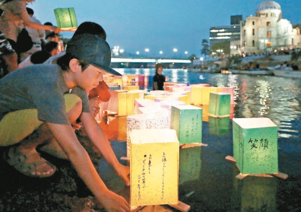 民眾在廣島和平紀念公園河邊放漂流紙燈，安慰原爆罹難者亡靈。圖／歐新社